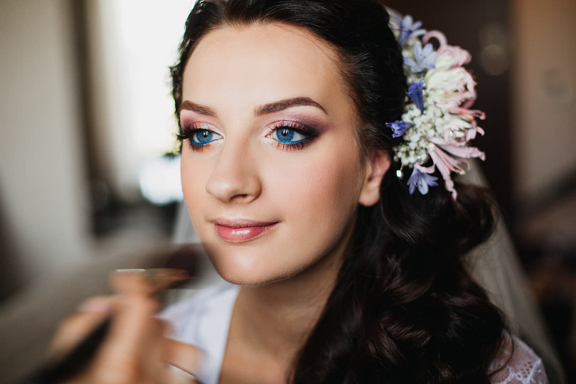 A bride getting her makeup done with very elaborate eye shadow