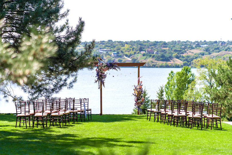 Beautiful view of an outdoor wedding setup overlooking a lake in the background