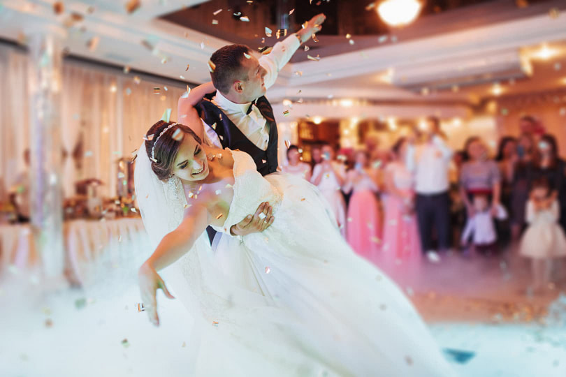 Bride and groom dancing the night away on the dance floor in front of their wedding guests