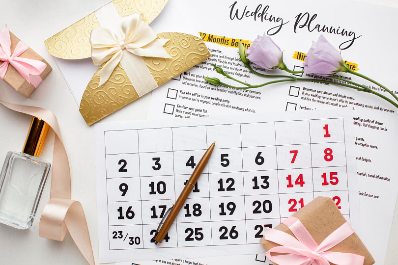 A calendar on a table with a wedding planning checklist next to it